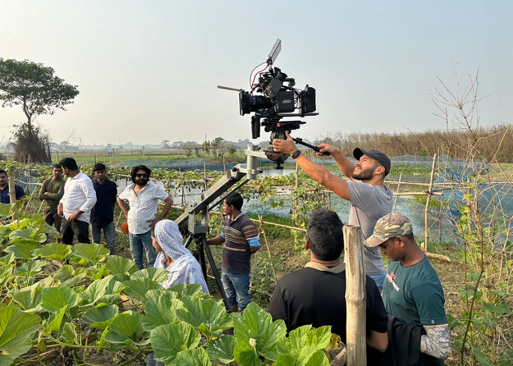 Camera crew operating a jib crane for a video shoot in rural Bangladesh