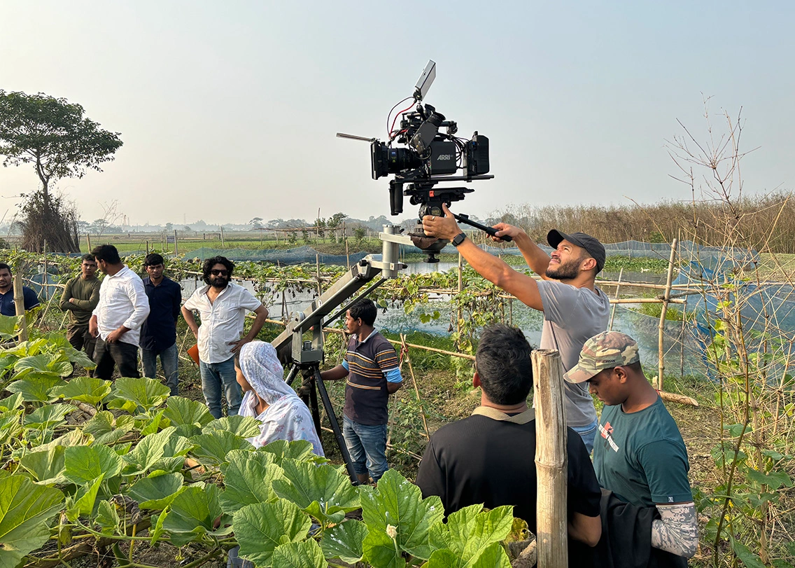 Camera crew operating a jib crane for a video shoot in rural Bangladesh