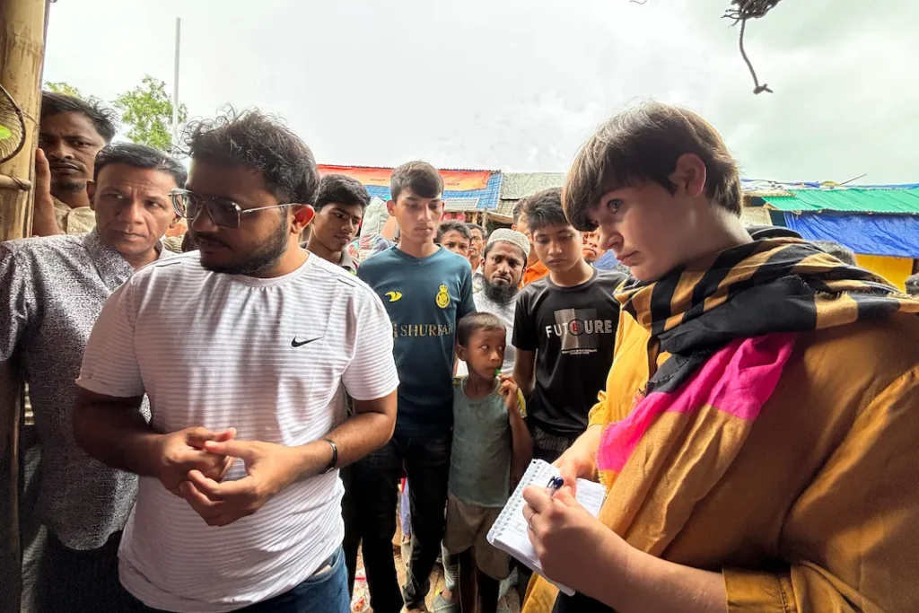 Local fixer coordinating filming access in Rohingya camp demonstrating compliance navigation and security briefing for media crews