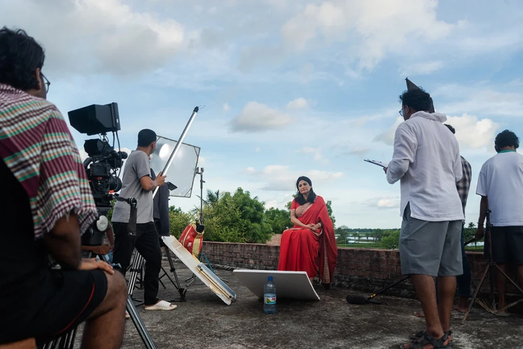 Foreign documentary crew with local fixer and sound recordist filming on location in Bangladesh