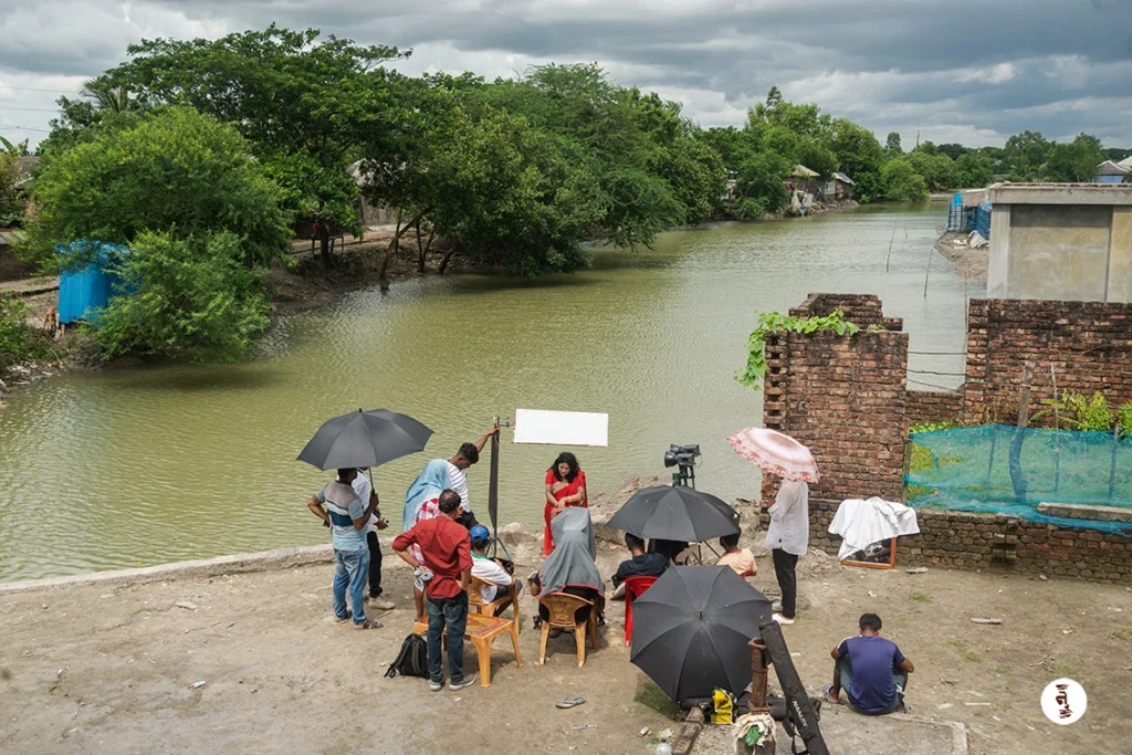 Film crew recording audio and video of a tea worker in the Sundarbans, illustrating regional dialect translation support.