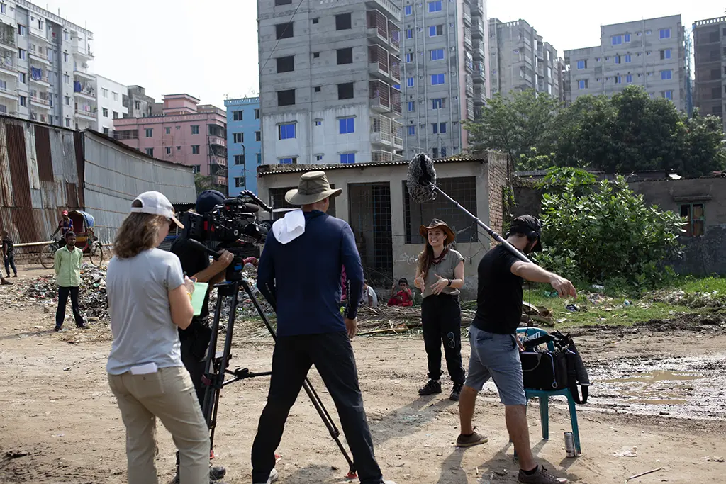 Documentary crew filming in Old Dhaka streets with fixer managing crowd control Bangladesh production