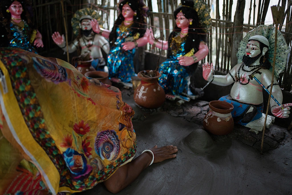 Traditional Bonobibi worship scene showing painted statues of Bonobibi and other deities with offerings. These rituals once drew Hindu and Muslim communities together for protection against storms, tigers, and crocodiles in the Sundarbans.