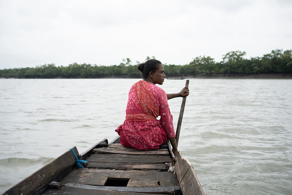 Buli Dasi preparing to enter the Sundarbans mangrove to hunt for crabs and fish in jungle canals. She prays to Bonobibi for protection before each journey into the dangerous forest.