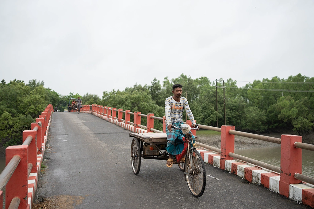 Hafezur, 30, who abandoned his family's fishing profession after his father was killed by a tiger. He now pulls a rickshaw in Shyamnagar bazar, representing the shift away from forest-dependent livelihoods due to climate change and danger.