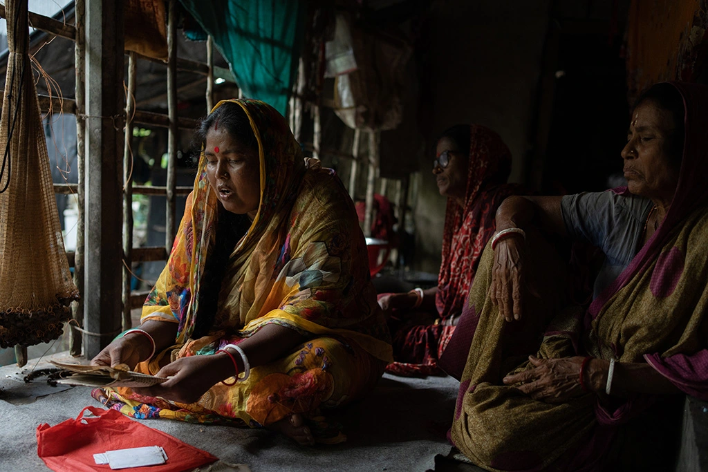 Women in the Sundarbans performing Bonobibi songs inside a village home, reflecting climate loss and cultural survival